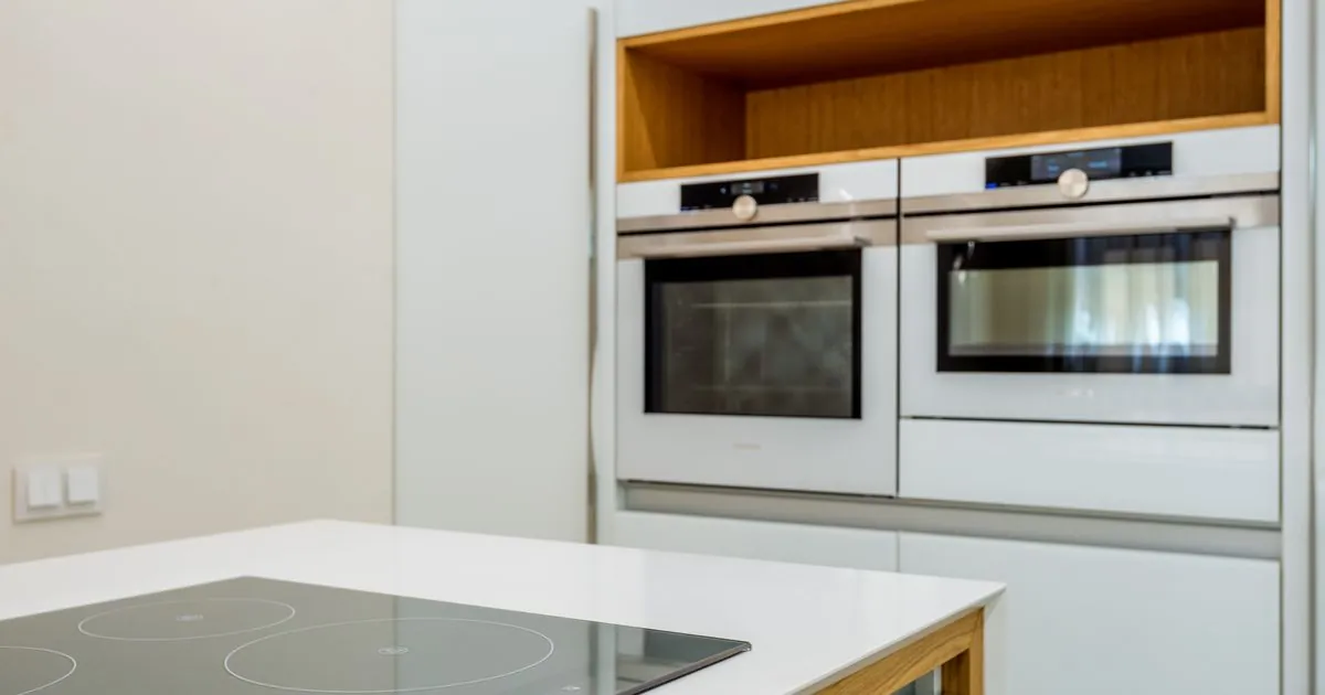 Moderne Einbauküche mit Induktionskochfeld und eingebauten Backöfen nach fachgerechter Elektroinstallation, Ratgeber von Rucker Elektro München