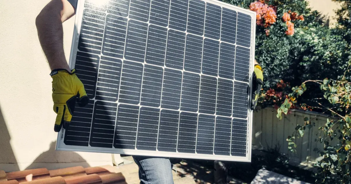 Monteur trägt Solarmodul auf Hausdach bei Wallbox installieren lassen Kombination, Ratgeber von Rucker Elektro München