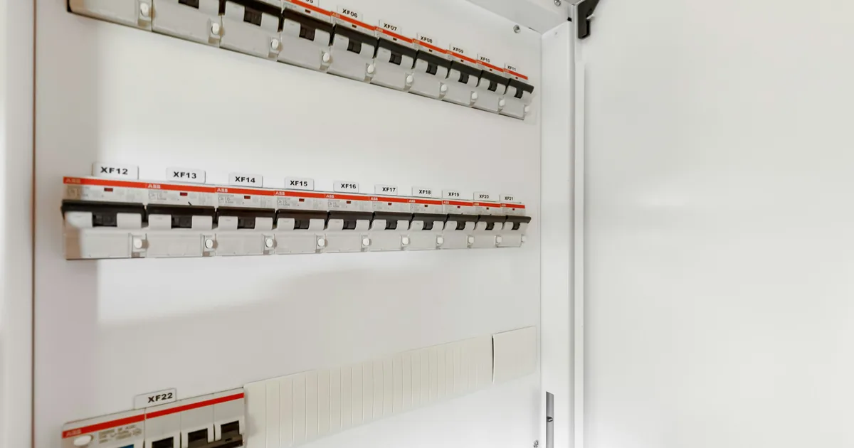 Geöffneter Verteilerschrank mit beschrifteten Leitungsschutzschaltern auf zwei Hutschienen