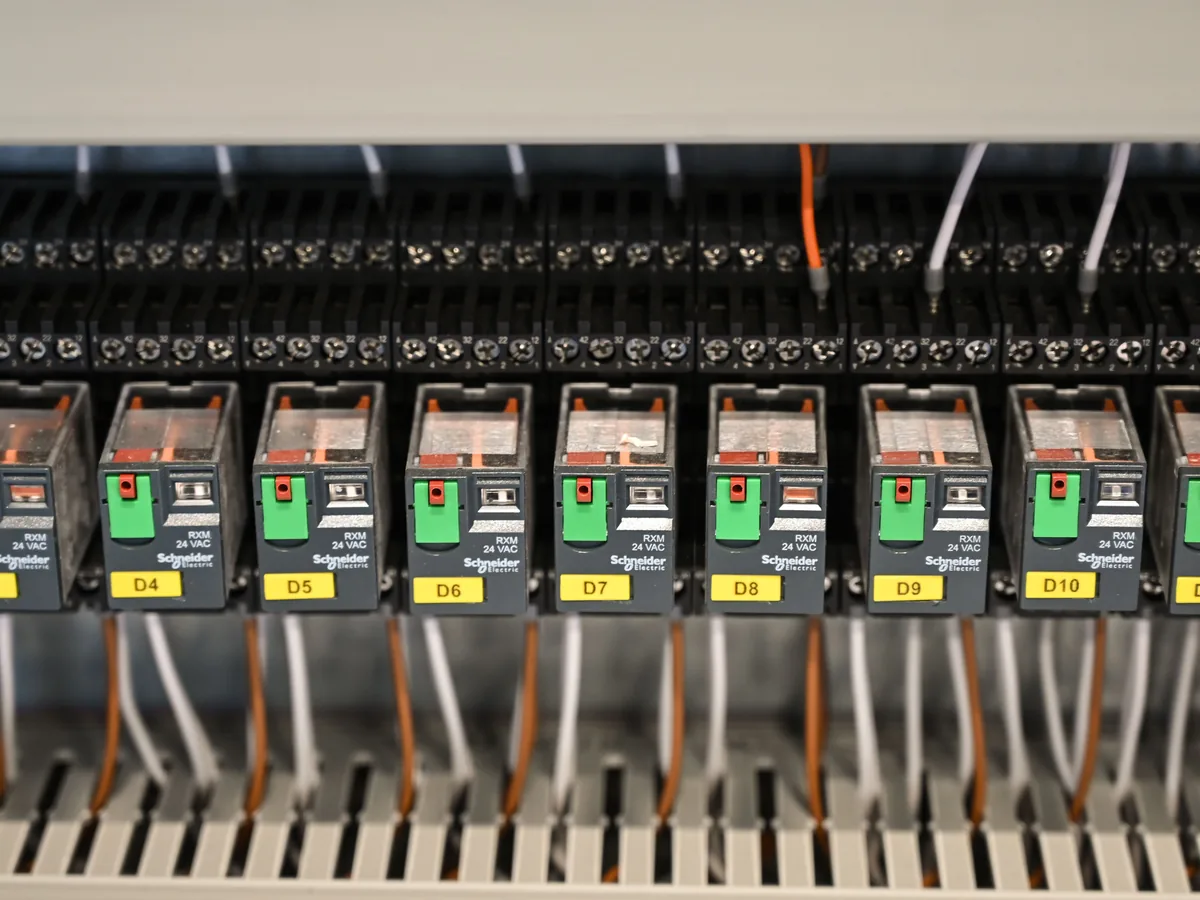 Beschriftete Relaisreihe in einer Schaltanlage, Positionen einzeln gekennzeichnet, Elektrotechnik für Gewerbe und Hausverwaltungen in München, Rucker Elektro