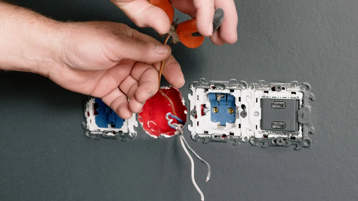 Elektriker verdrahtet einen Steckdoseneinsatz in der Installationsdose