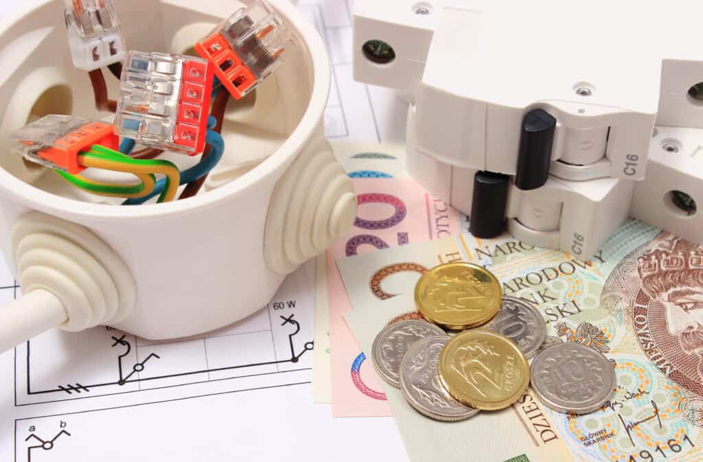 Elektroinstallation mit Klemmen, Sicherungsautomat und Geld – Symbol für Stromkosten.