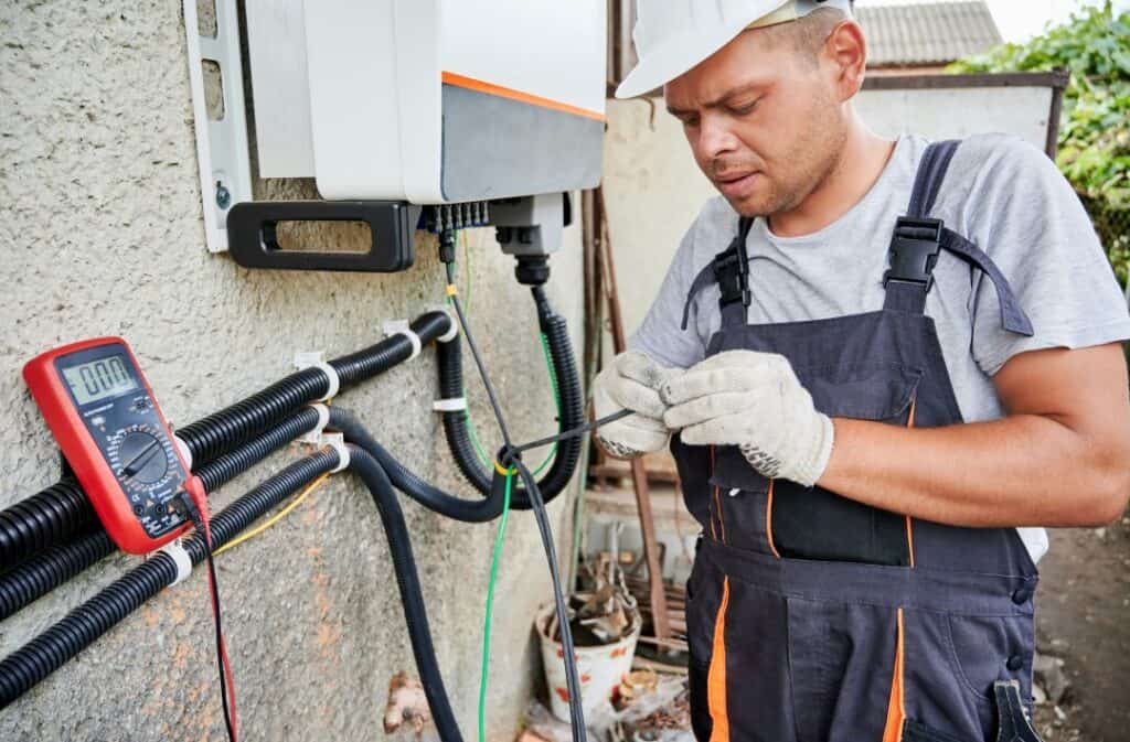 Elektriker überprüft Solaranlage und Stromverbrauch im Außenbereich.