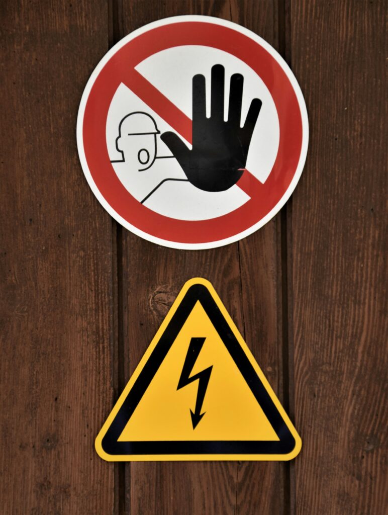 Warnschild Zutritt verboten und Hochspannung Symbol an Holzwand – Elektrosicherheit im Betrieb
